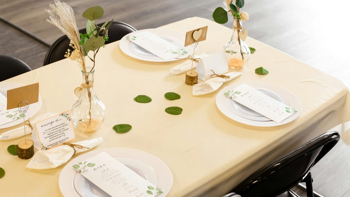 Wood place card holders and floral place settings arranged on a cream dining table