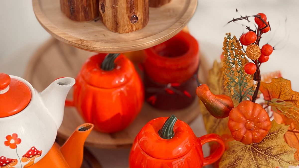 Wood tiered risers styled with pumpkin ceramics, candles and autumn leaves