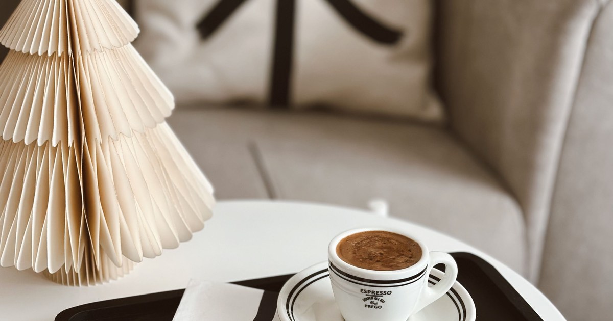 Neutral Christmas coffee table with a paper tree, dark tray, and espresso cup